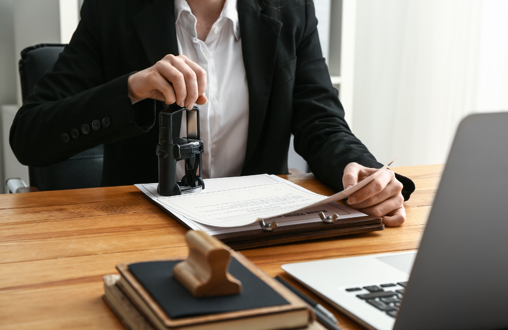 notaire apposant un sceau officiel sur un document, étape clé dans la succession et la recherche d’héritiers